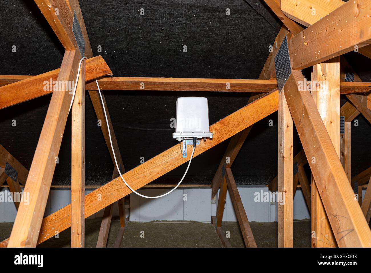 Antennenverstärker für mobiles Internet zu Hause, montiert auf Dachstühlen im Dachgeschoss. Stockfoto