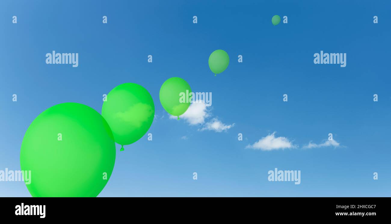 Grüne Luftballons vor einem blauen Himmel mit weißen Wolken Stockfoto