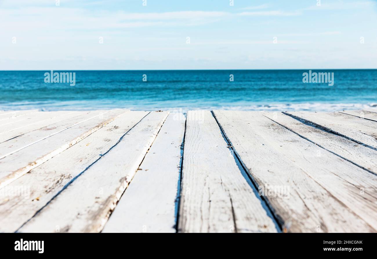 Weiße Holzterrasse am Meer mit Blick auf den Horizont über dem Wasser Stockfoto