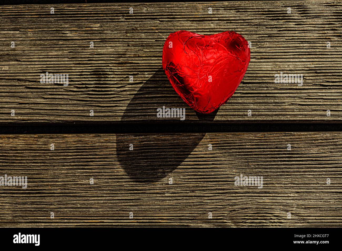 Rotes Schokoladenherz auf altem Holz Stockfoto