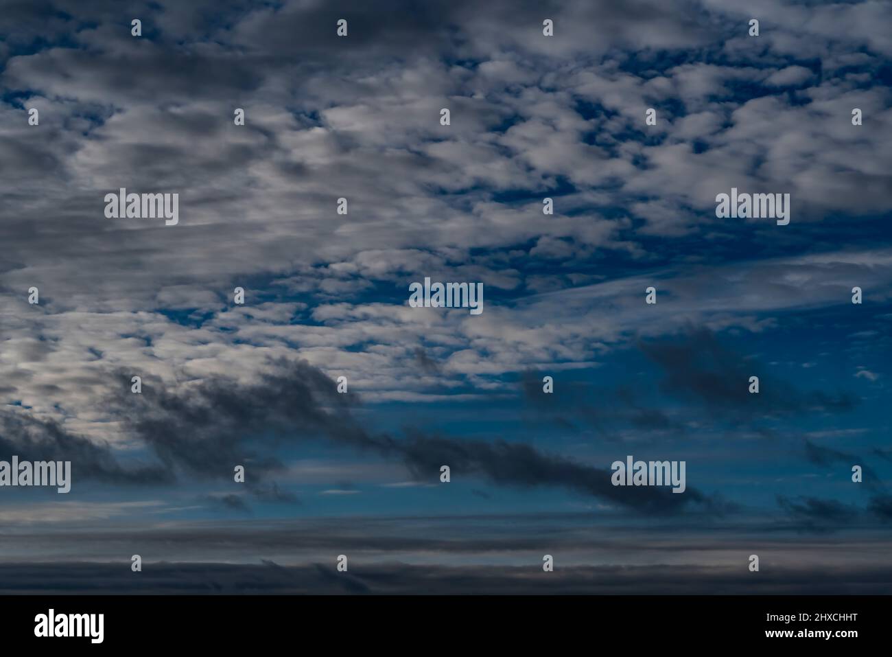 Regenwolken vor blauem Himmel im Winter in Deutschland Stockfoto