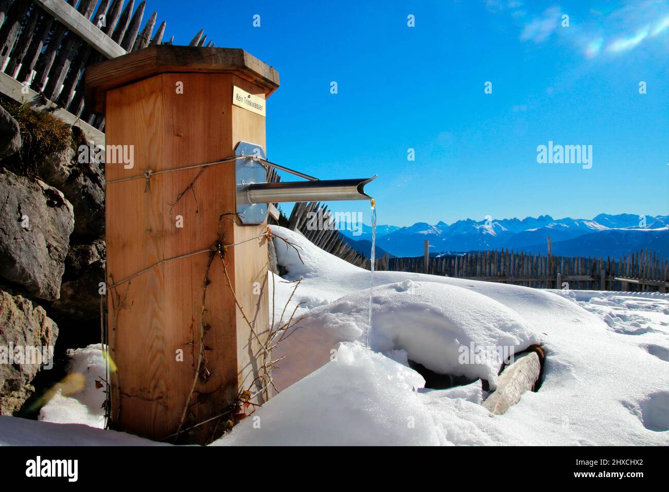 Winterwanderung zur Wang Alm im Gaistal, Brunnen vor einem Bergpanorama, Österreich, Tirol, Urlaub, Winter, Perfektes Wetter Stockfoto