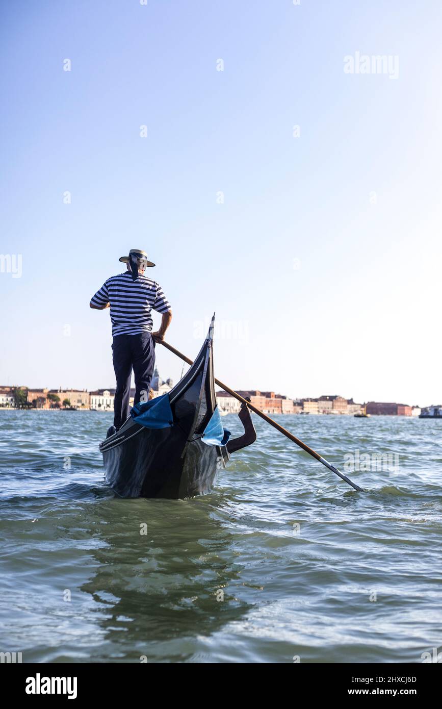 Rückansicht einer Gondel mit Gondoliere in der Lagune von Venedig Stockfoto