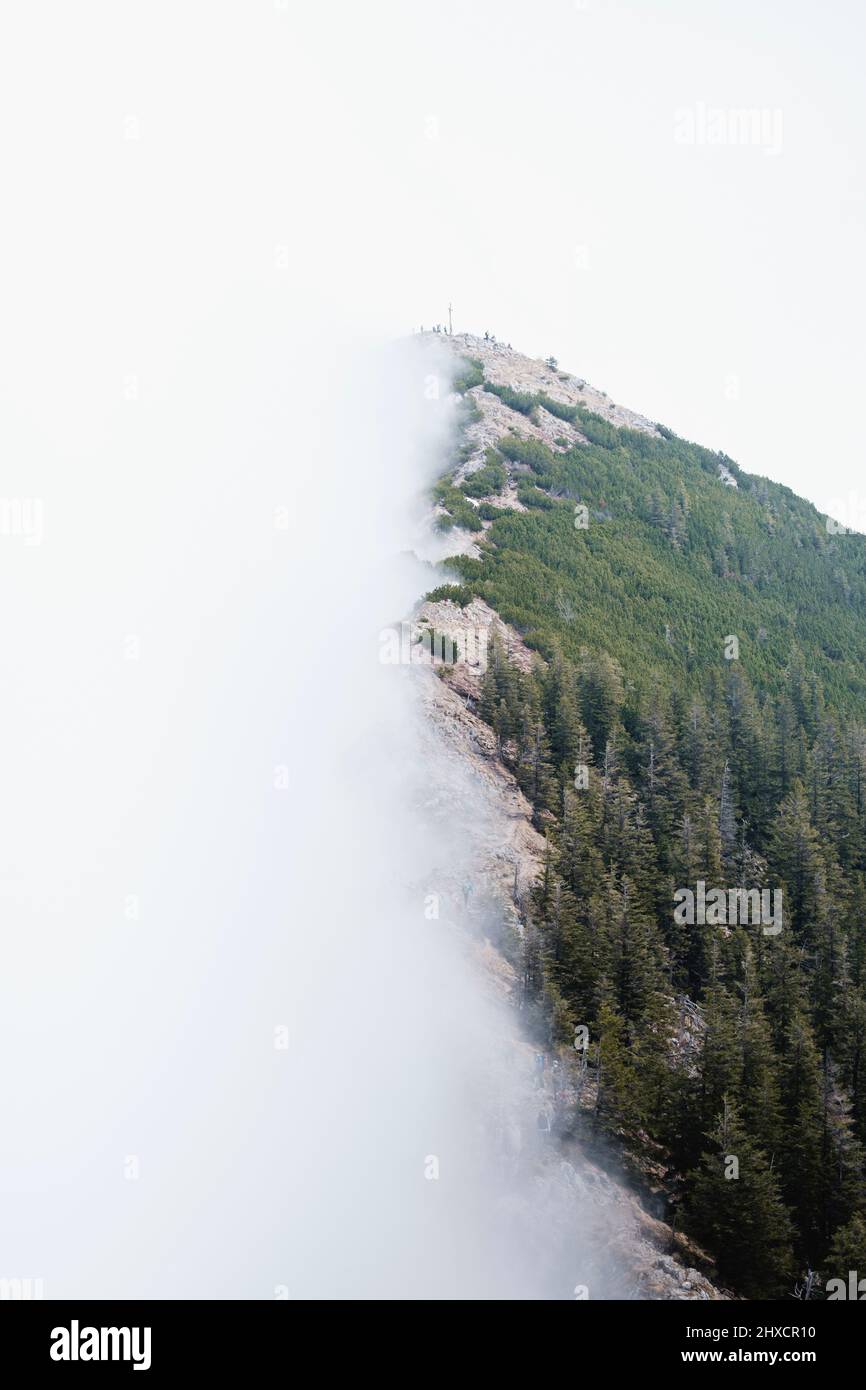 Nebelwand, die über den Bergrücken schiebt Stockfoto