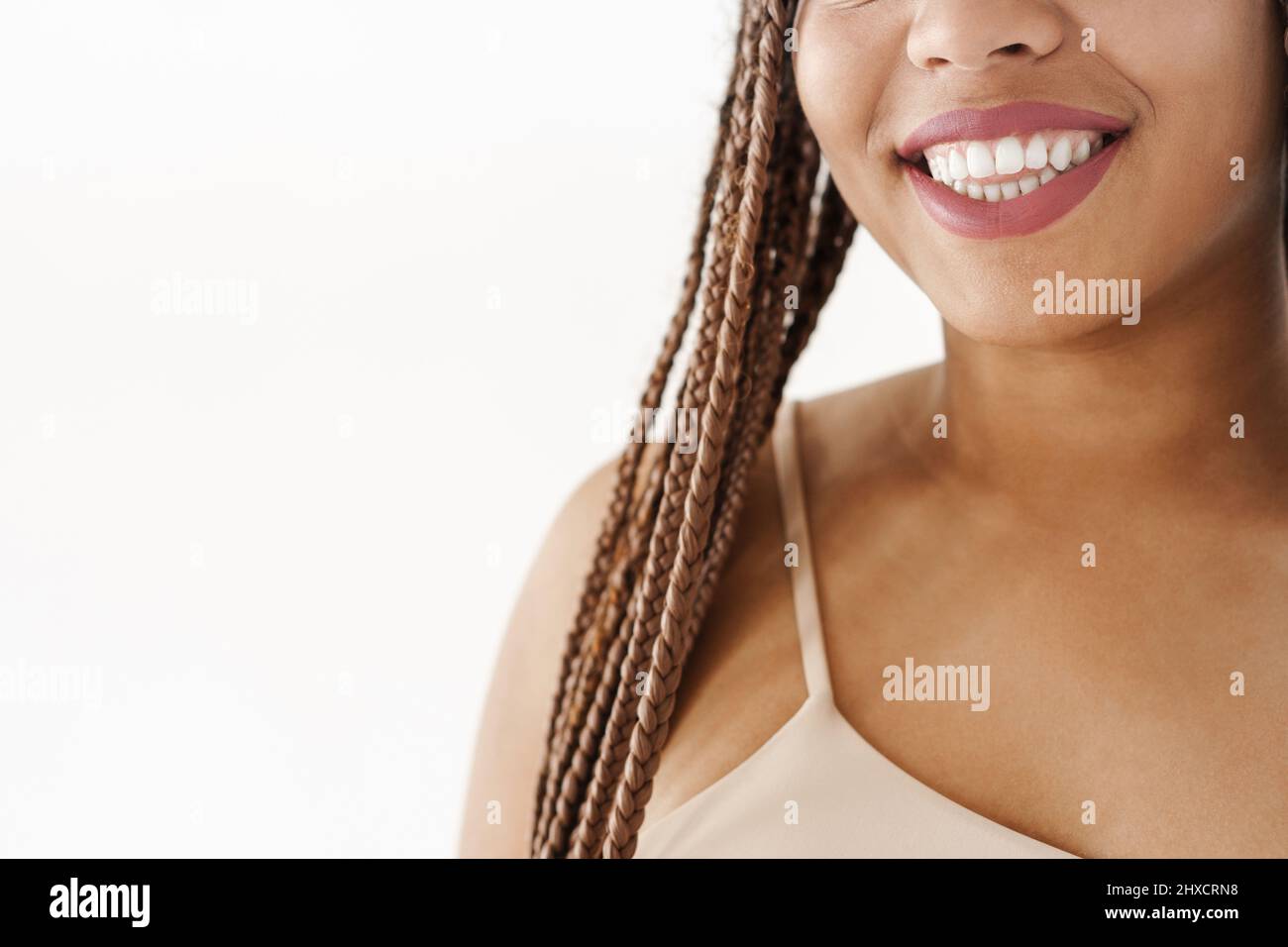 Lächelnde junge afrikanische Frau mit Dreadlocks über weißem Wandhintergrund zugeschnittenes Bild Stockfoto