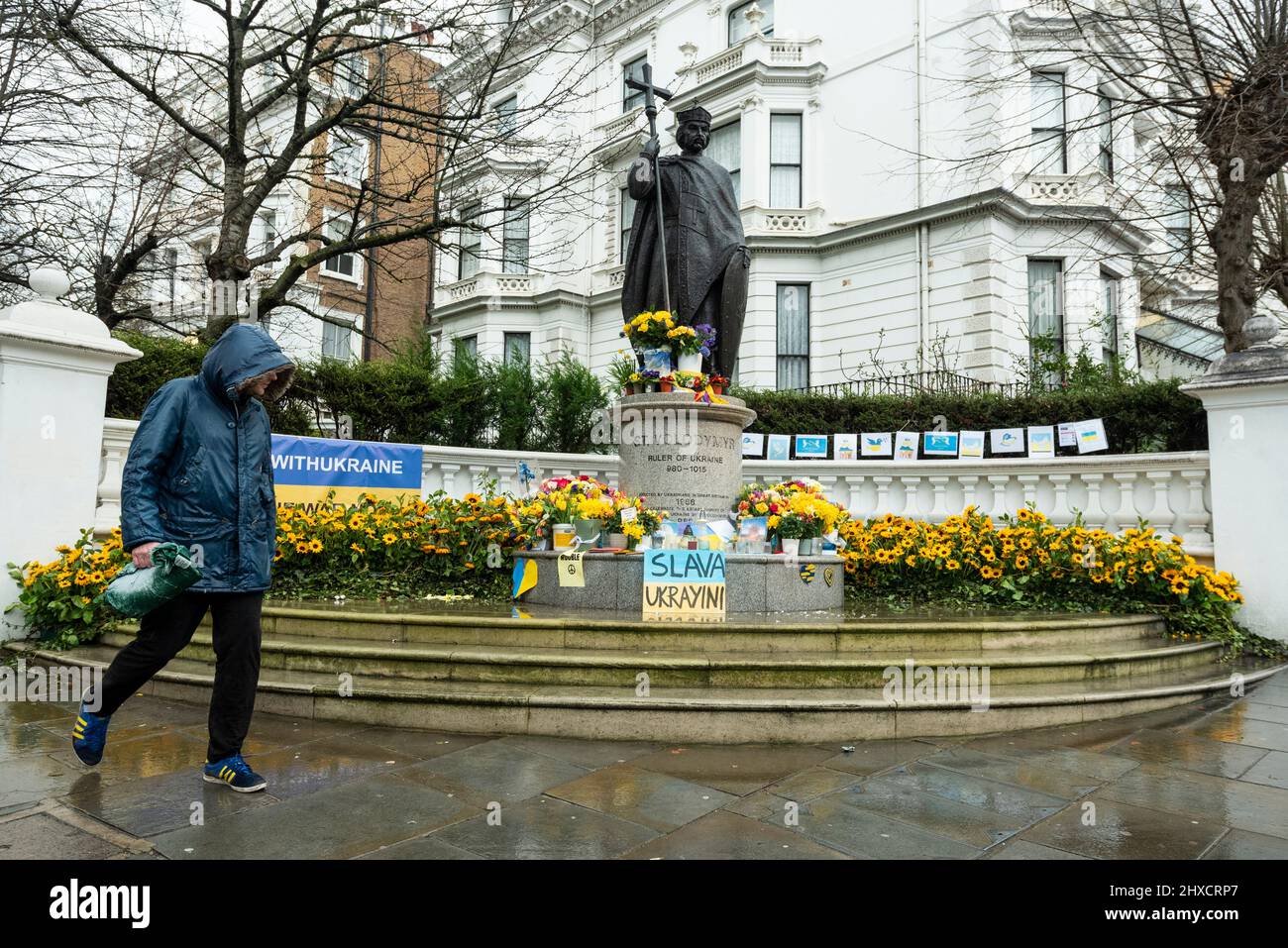 London, Großbritannien. 11. März 2022. Die Statue des hl. Wolodymyr, Herrscher der Ukraine 980-1015, ist in der Nähe des Holland Parks zu sehen, umgeben von Sonnenblumen und Botschaften der Unterstützung der Ukraine. Die Statue wurde von Ukrainern in Großbritannien errichtet, um die Gründung des Christentums in der Ukraine durch den heiligen Wolodymyr im Jahr 988 zu feiern. Der derzeitige Führer und Namensvetter der Ukraine, Präsident Wolodymyr Zelenskyy, führt die Ukraine bei ihrer Verteidigung gegen die russische Invasion an. Kredit: Stephen Chung / Alamy Live Nachrichten Stockfoto