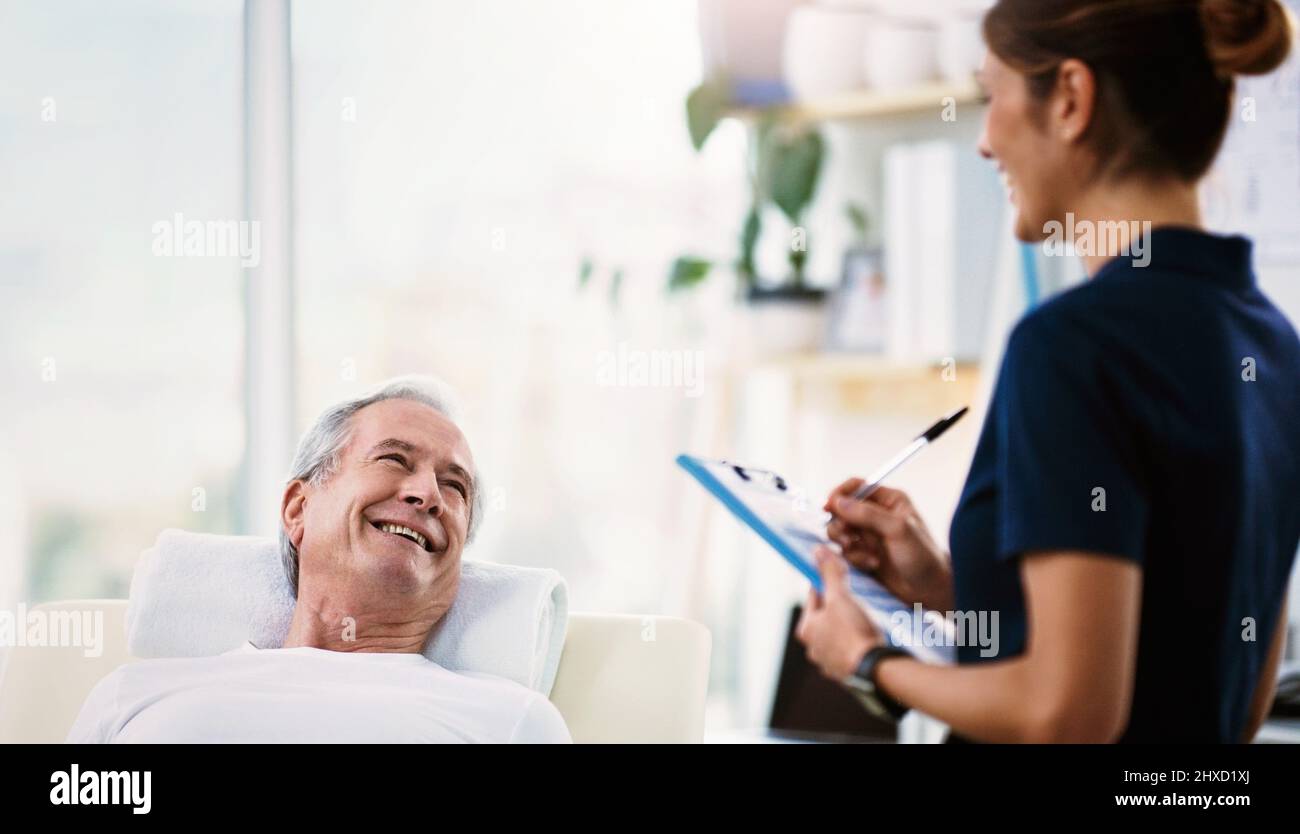 Waren beide zufrieden mit seinem Fortschritt. Aufnahme einer jungen Physiotherapeutin, die eine Konsultation und Beurteilung einer älteren Patientin macht. Stockfoto