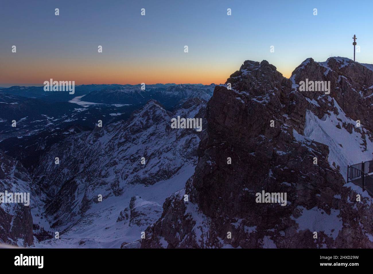 Morgenstimmung auf der Zugspitze, Sonnenaufgang auf Deutschlands höchstem Berg 'Top of Germany'. Landschaftsfotografie mit Zugspitzkreuz (4,88 m). Blick ins Höllental. Sichtbar sind: Alpspitze, Ferrata, Sofern, Viererspitze, Mittenwald, Wallgau. Stockfoto