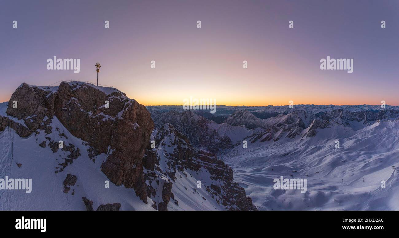 Morgenstimmung auf der Zugspitze, Sonnenaufgang auf Deutschlands höchstem Berg 'Top of Germany'. Landschaftsfotografie mit Zugspitzkreuz (4,88 m). Panorama bestehend aus ca. 5 Bildern. Stockfoto