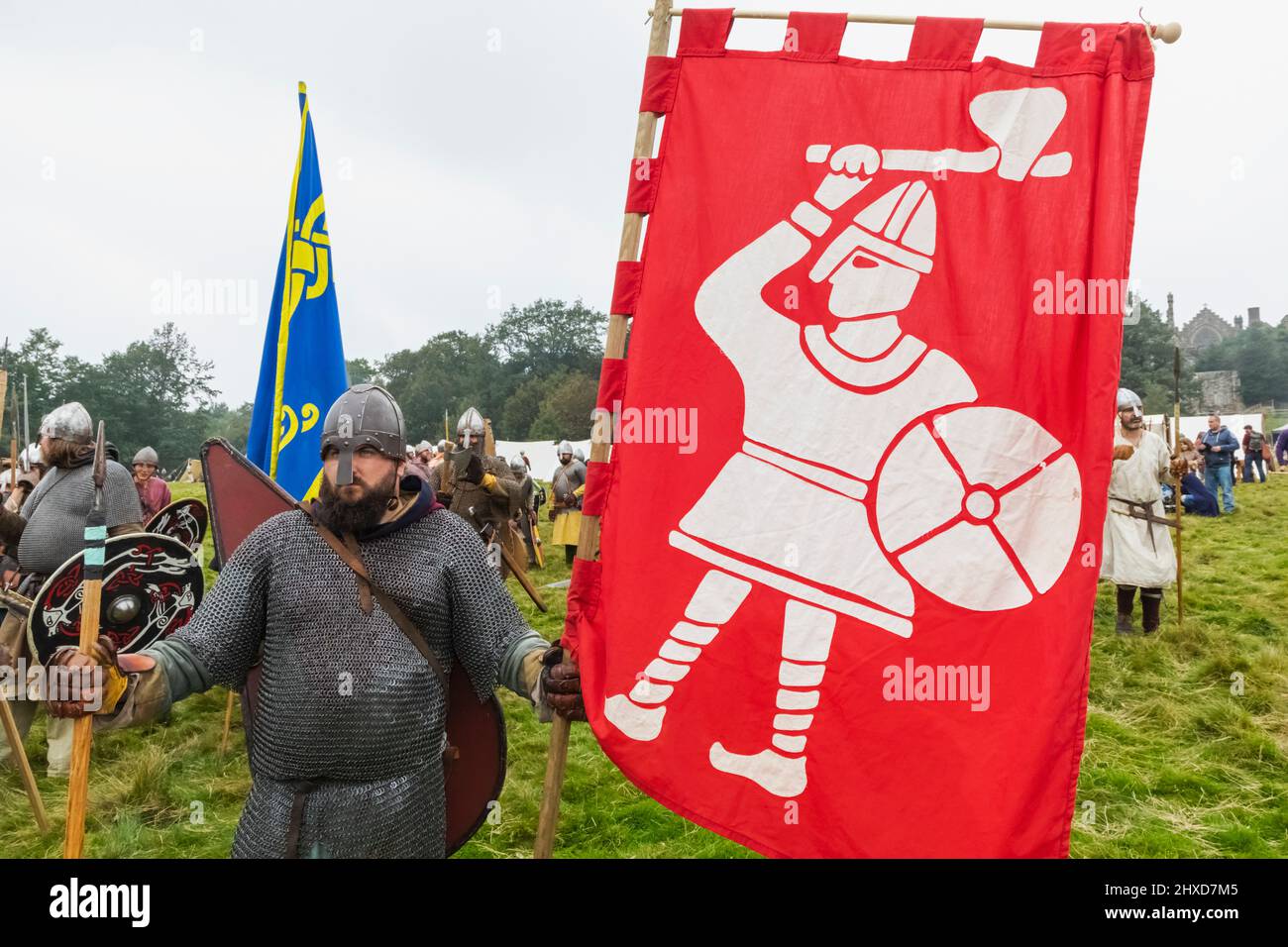England, East Sussex, Battle, The Annual Battle of Hastings 1066 Re-enactment Festival, Teilnehmer gekleidet in mittelalterliche Sächsische Rüstungsholding Flagge Stockfoto
