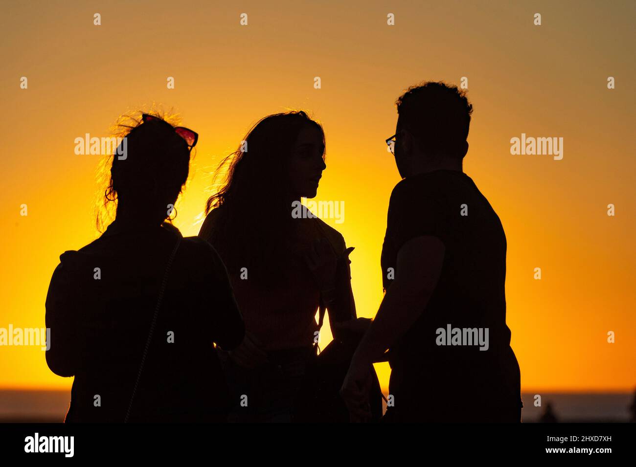 Silhouette von drei Personen im Sonnenuntergang am Strand, Santa Monica, Kalifornien, USA Stockfoto