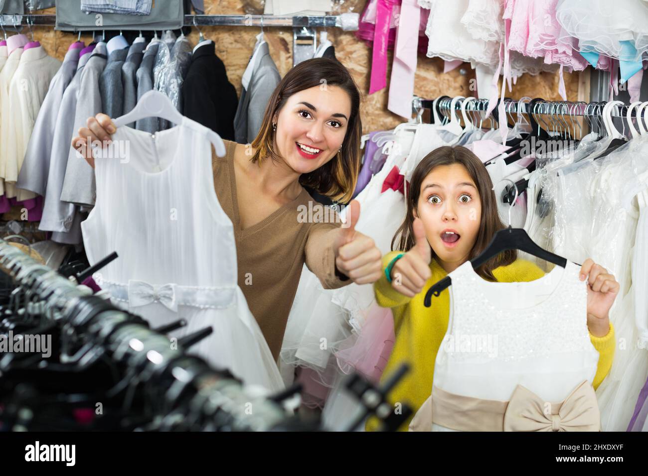 Frau 25-29 Jahre alt mit Mädchen 10-15 Jahre alt zeigen ihre Einkäufe Stockfoto