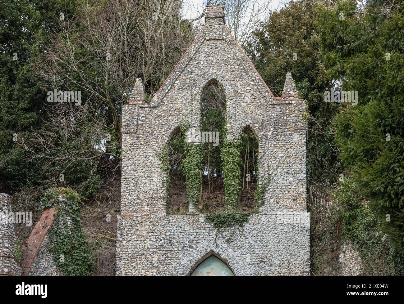 Altes und historisches Gebäude, das ruiniert wurde und durch ein Fenster Efeu wächst Stockfoto