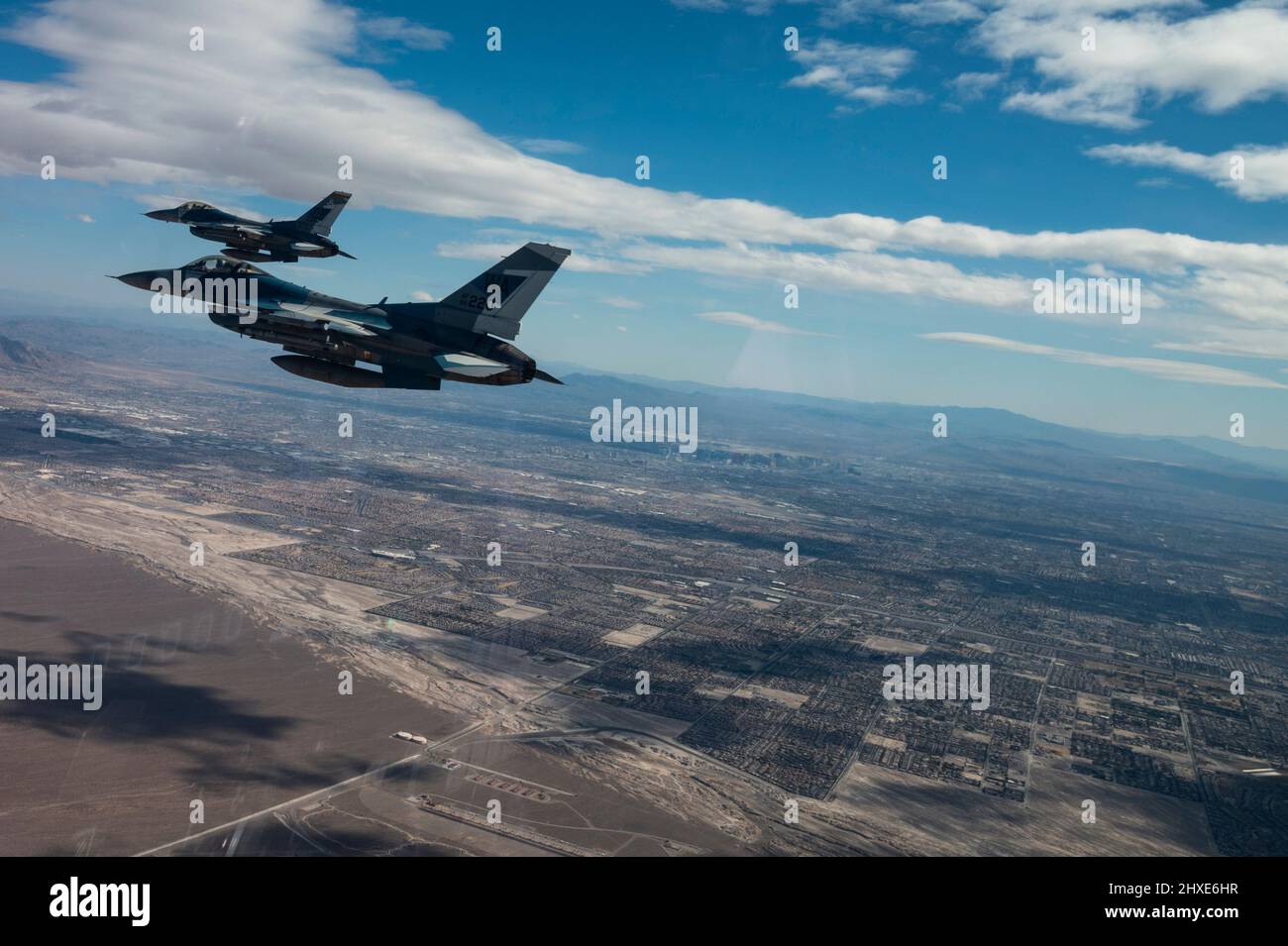 Zwei F-16-Kampffalken, die der 64. Aggressor Squadron zugewiesen wurden, fliegen auf dem Rückweg nach der Durchführung von Luftkampfoperationen während der Red Flag-Nellis 22-2 am 9. März 2022 auf der Nellis Air Force Base, Nevada, an der Innenstadt von Las Vegas vorbei. Red Flag-Nellis 22-2 ist eine einzigartige Übung, die die modernste taktische Integration der Luftwaffe der USA und ihrer wichtigsten Verbündeten demonstriert. (USA Air Force Foto von Tech. Sgt. Alexandre Montes) Stockfoto