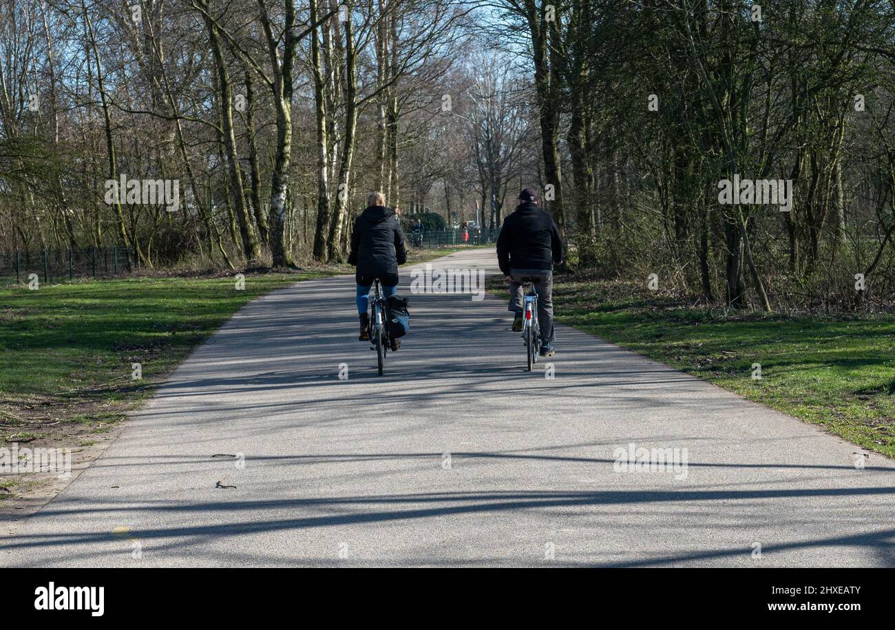 Nicht erkennbare Menschen radeln und genießen ihren Tag im Park namens Haarlemmermeerse bos in Hoofddorp in den Niederlanden Stockfoto