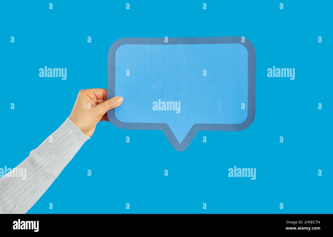 Anonyme Frau mit leerer blauer Papierblase auf blauem Hintergrund Stockfoto