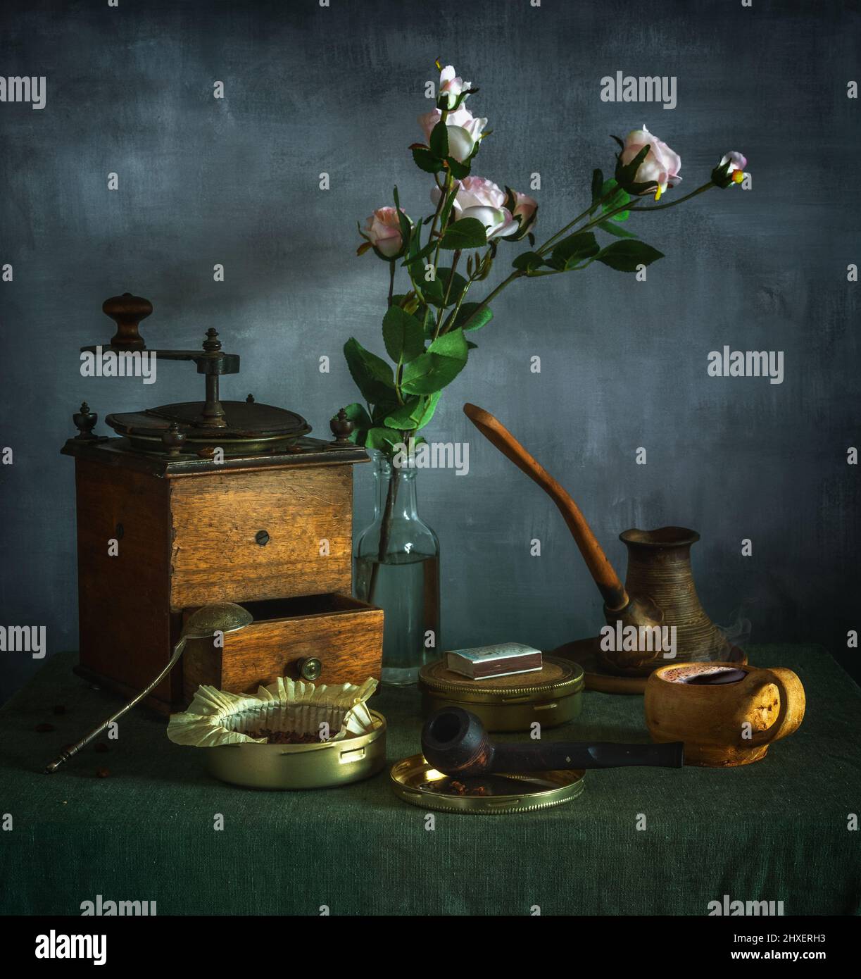 Stillleben mit einem Blumenstrauß, einer Tasse Kaffee, einer alten Kaffeemühle und einer Rauchpfeife. Vintage. Stockfoto