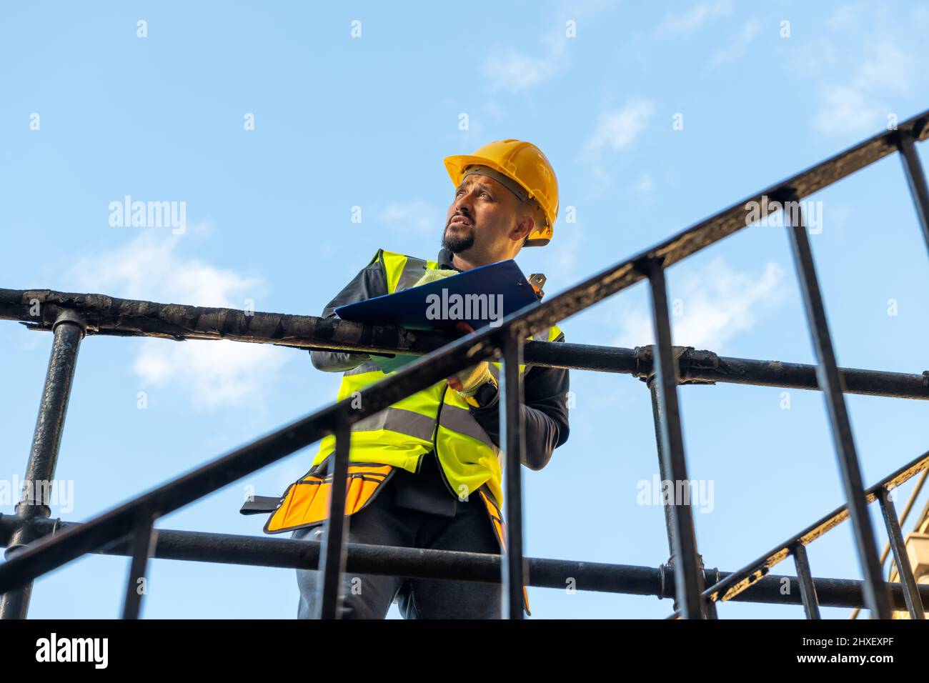 Ein Baumeister, der sich Notizen macht und die Bauarbeiten auf der Baustelle inspiziert. Stockfoto