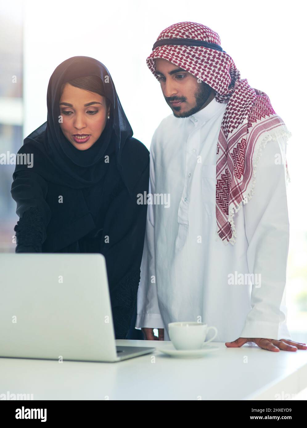 Zeit, um Ergebnisse zu erzielen. Aufnahme von zwei muslimischen Kollegen, die in einem modernen Büro einen Laptop zusammen benutzen. Stockfoto