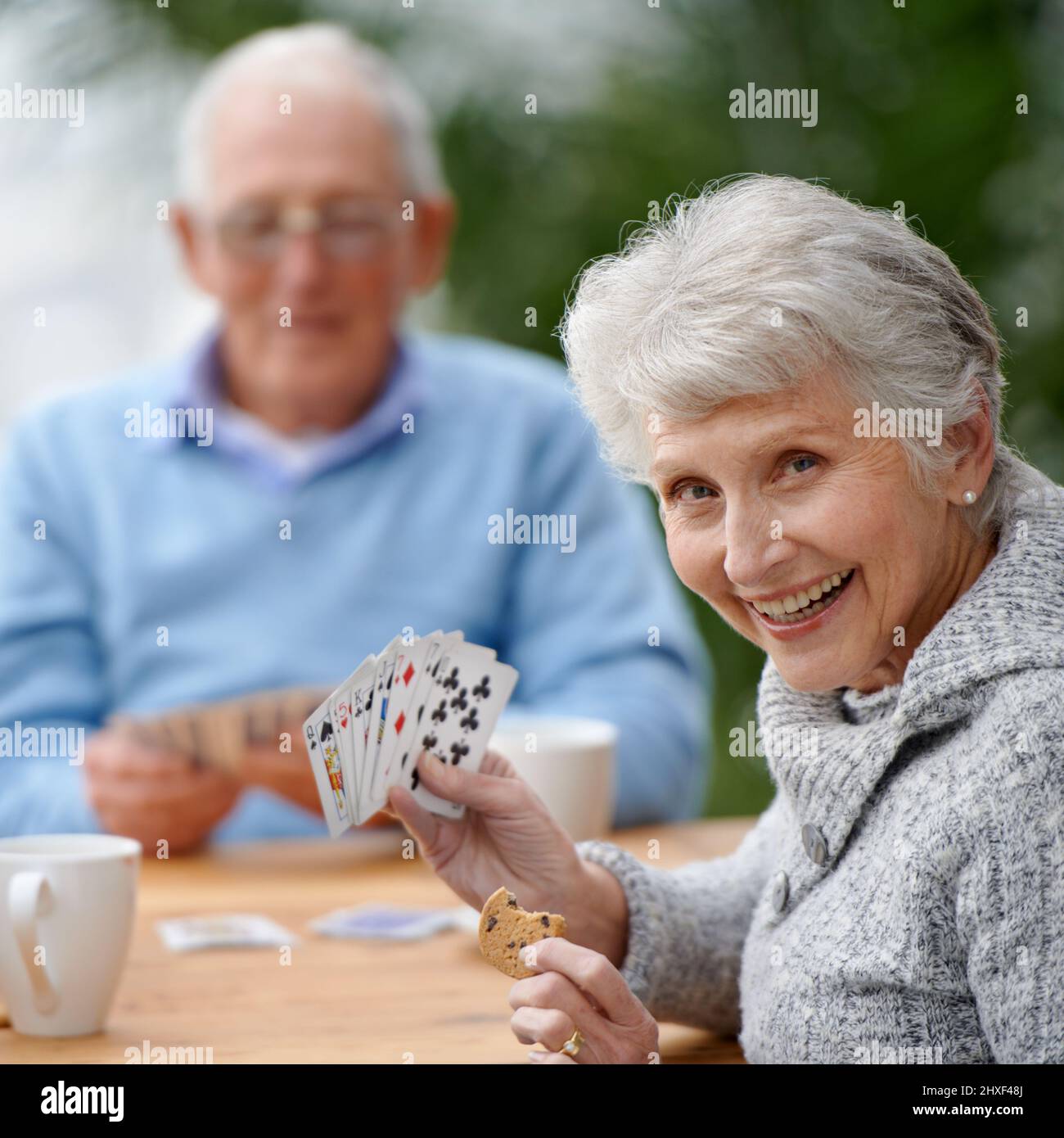 Mit Kartenspielen die Zeit verstreichen lassen. Zwei Senioren spielen zusammen Karten. Stockfoto