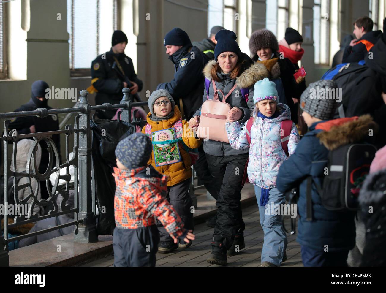 LVIV, UKRAINE - 11. MÄRZ 2022 - Eine Frau und Kinder werden auf der Plattform abgebildet, während Menschen, die vor der russischen Invasion fliehen, auf einen Evakuierungszug warten Stockfoto
