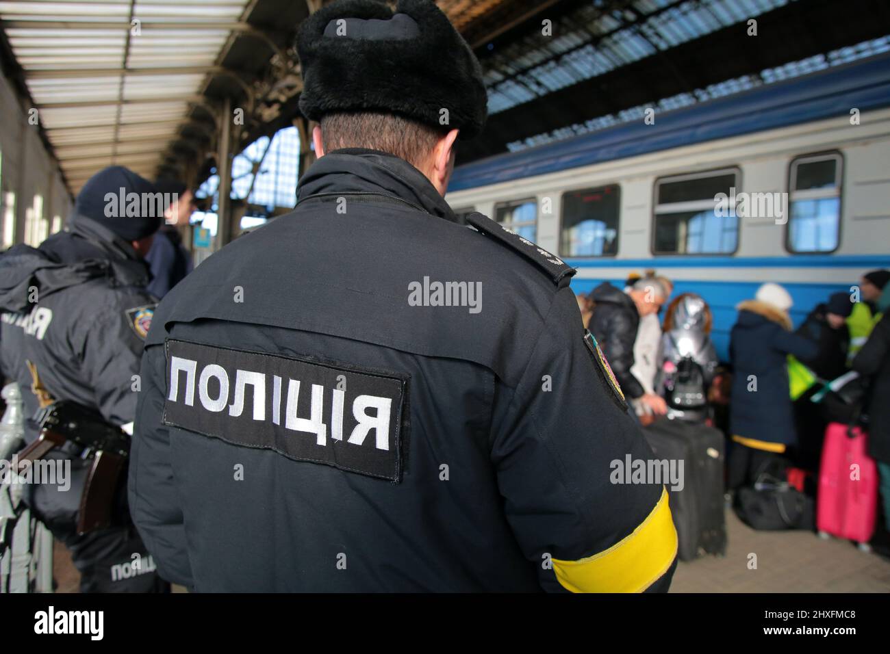 LVIV, UKRAINE - 11. MÄRZ 2022 - Polizeibeamte stehen Wache, während Menschen, die vor der russischen Invasion fliehen, auf einen Evakuierungszug nach Przemysl, Polen, AT warten Stockfoto
