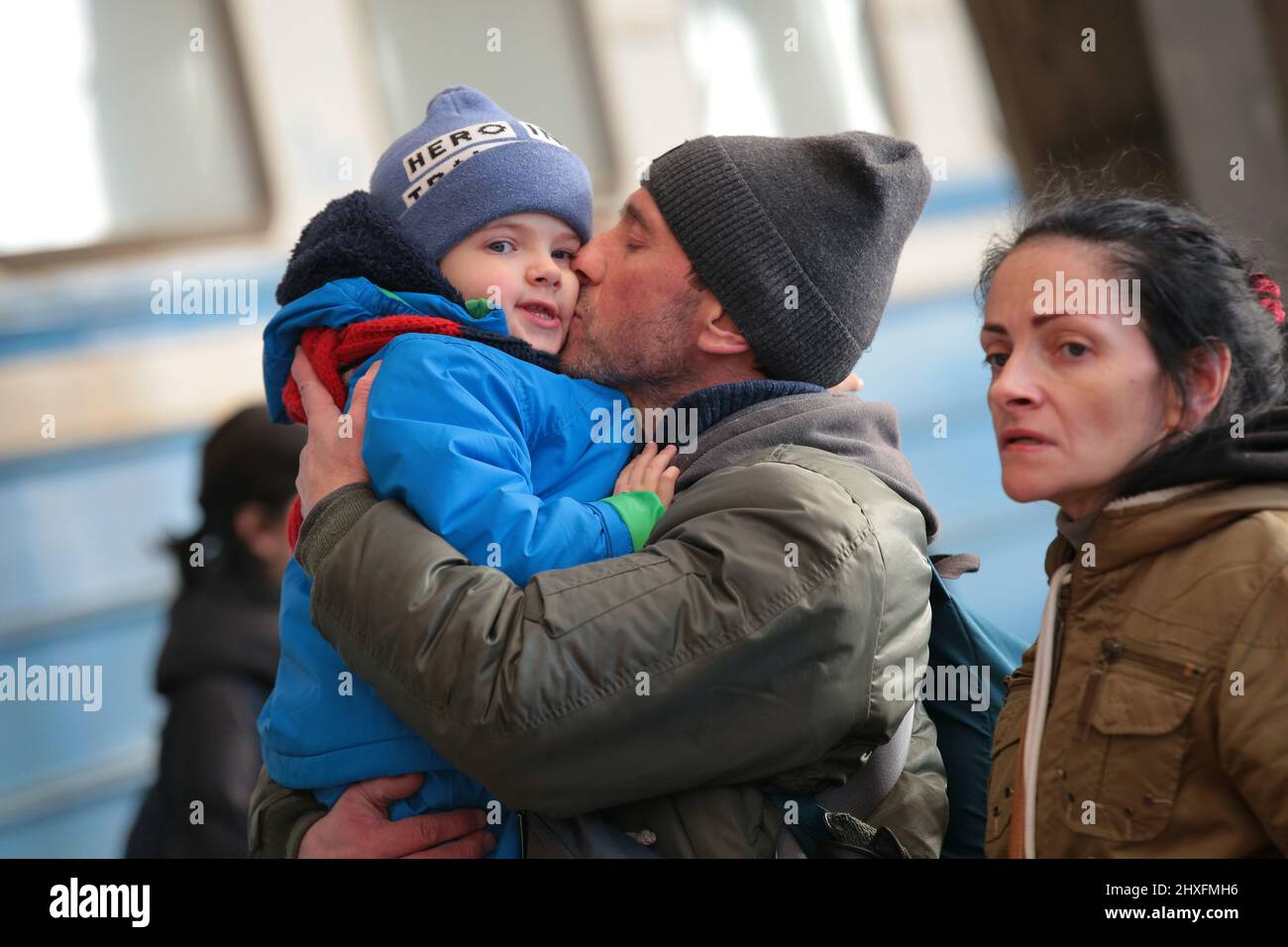 LVIV, UKRAINE - 11. MÄRZ 2022 - Ein Mann küsst einen Jungen, während Menschen, die vor der russischen Invasion fliehen, auf einen Evakuierungszug nach Przemysl, Polen, warten Stockfoto