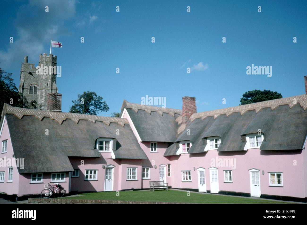Malerischer Blick auf rosafarbene Reethäuser und das Kirchdorf Cavendish, Suffolk, England, mit hellblauem Himmel und Kopierfläche. Stockfoto