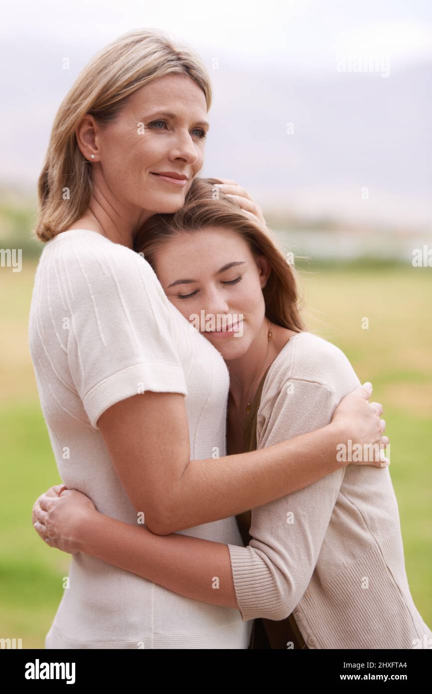 Jeder braucht ab und zu eine Umarmung wie diese. Eine Mutter umarmt ihre Tochter. Stockfoto