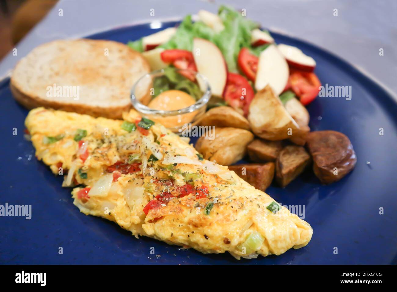 Omelette, Omelette oder Rührei mit Salat und gebratener Kartoffel und Dressing Stockfoto