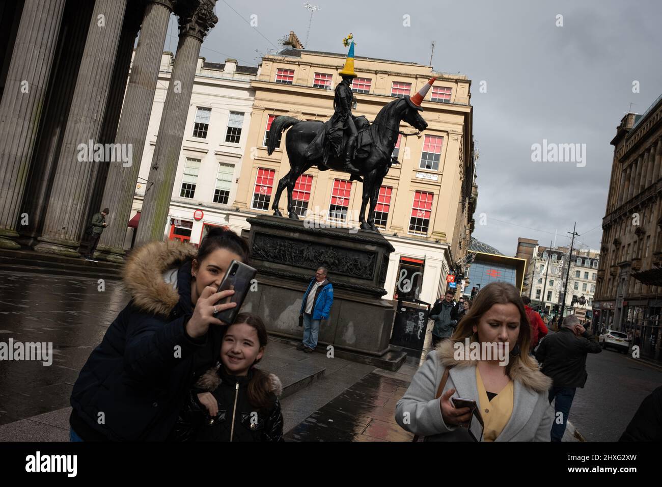 Glasgow, Großbritannien, 12.. März 2022. Die Statue des Herzogs von Wellington in der Queen Street trägt einen blau-gelben Polizeikegelhut mit ukrainischer Flagge, wie von Pauline McWhirter gehäkelt, zur Unterstützung der Ukraine in ihrem aktuellen Krieg mit Präsident PutinÕs Russia, in Glasgow, Schottland, 12. März 2022. Foto: Jeremy Sutton-Hibbert/Alamy Live News. Stockfoto