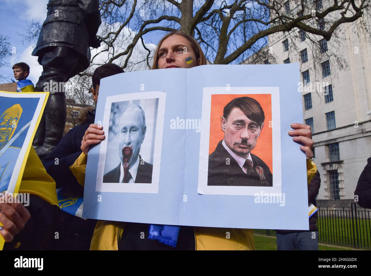 London, England, Großbritannien. 12. März 2022. Eine Frau hält ein Plakat, das Putin mit Hitler vergleicht. Demonstranten versammelten sich vor der Downing Street zur Unterstützung der Ukraine, während Russland seinen Angriff fortsetzt. (Bild: © Vuk Valcic/ZUMA Press Wire) Stockfoto