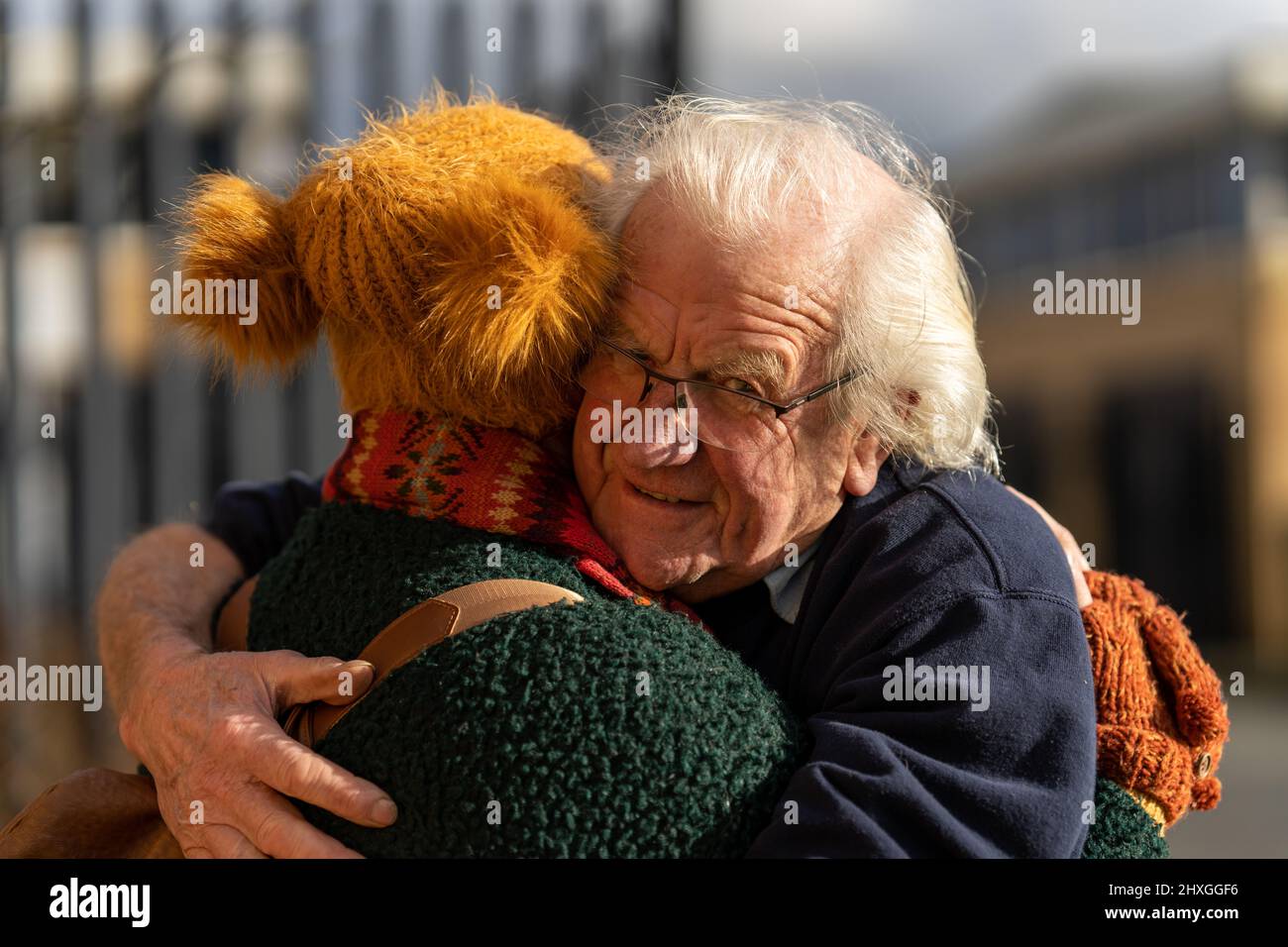 Großvater umarmt Enkelin nach langer Trennung und trifft sich draußen Stockfoto