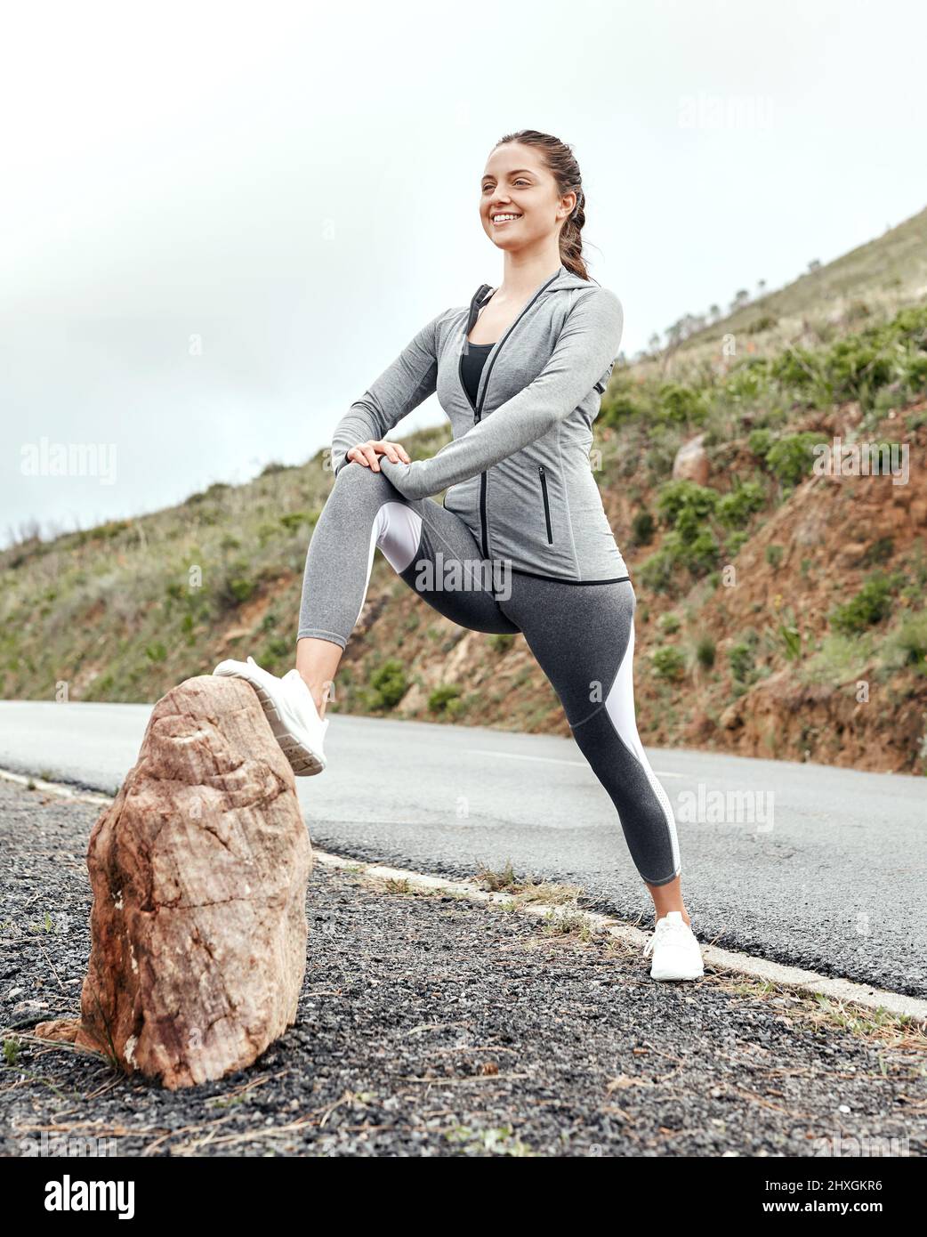 Laufen mit Muskeln, die nicht richtig vorbereitet sind, kann zu einer Belastung führen. Aufnahme einer sportlichen jungen Frau, die ihre Beine während des Trainings im Freien streckt. Stockfoto