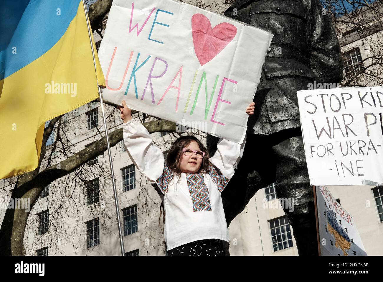 London, 12.. März 2022. Ukrainische Staatsbürger und Anhänger versammeln sich weiterhin in Whitehall gegenüber der Downing Street und fordern mehr Maßnahmen gegen Russland für die Invasion der Ukraine von der internationalen Gemeinschaft. Ein junges Mädchen hält ein Schild mit dem Titel „We Love Ukraine“ über der Menge. Stockfoto