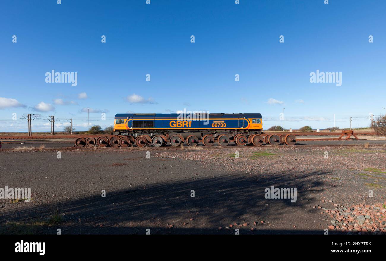 GB Railfreight Klasse 66 Diesel Lok 66733 in Falkland Hof, Ayr mit Gleisradsätzen daneben an einem sonnigen Tag mit blauem Himmel Stockfoto