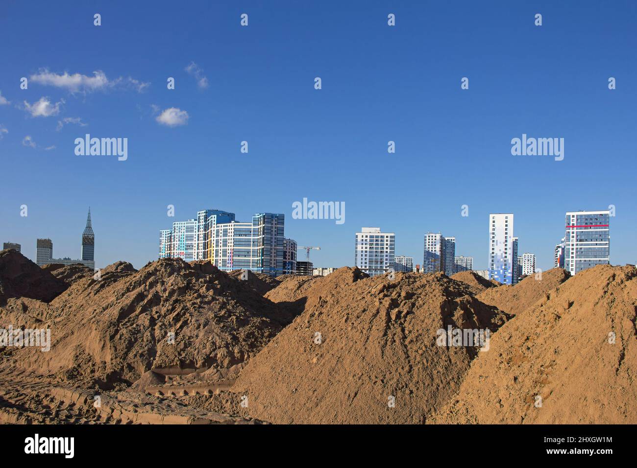 Der Sandhügel für den Bau und der Standort von neuen mehrstöckigen Gebäuden unterschiedlicher Architektur als Konzept schnell wachsender Städte Stockfoto