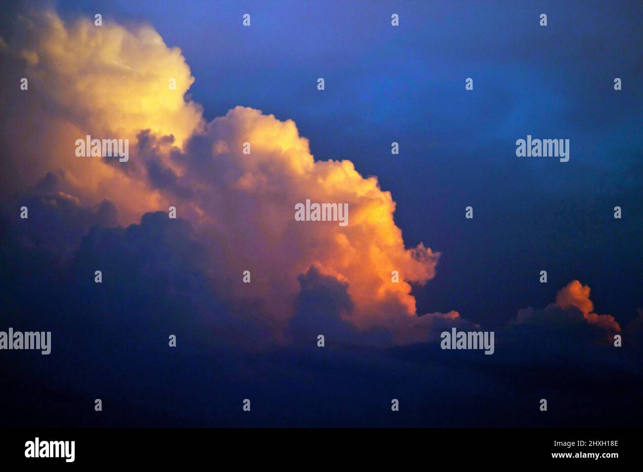 Farbenfrohe orange und violette Sommer-Cumulus-Sturmwolken bauen sich in der Atmosphäre unheimlich auf Stockfoto