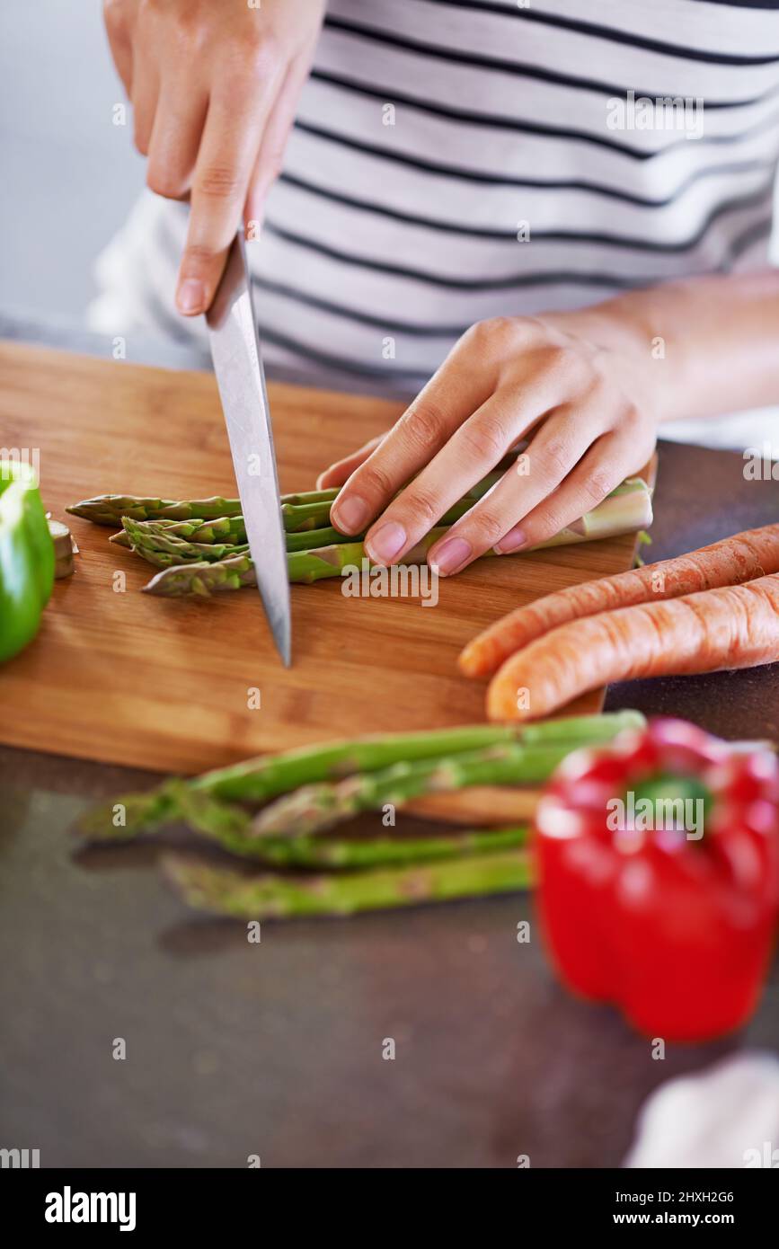 Zutaten für ein großartiges Leben. Kurzer Schuss einer Frau, die Gemüse hackt. Stockfoto