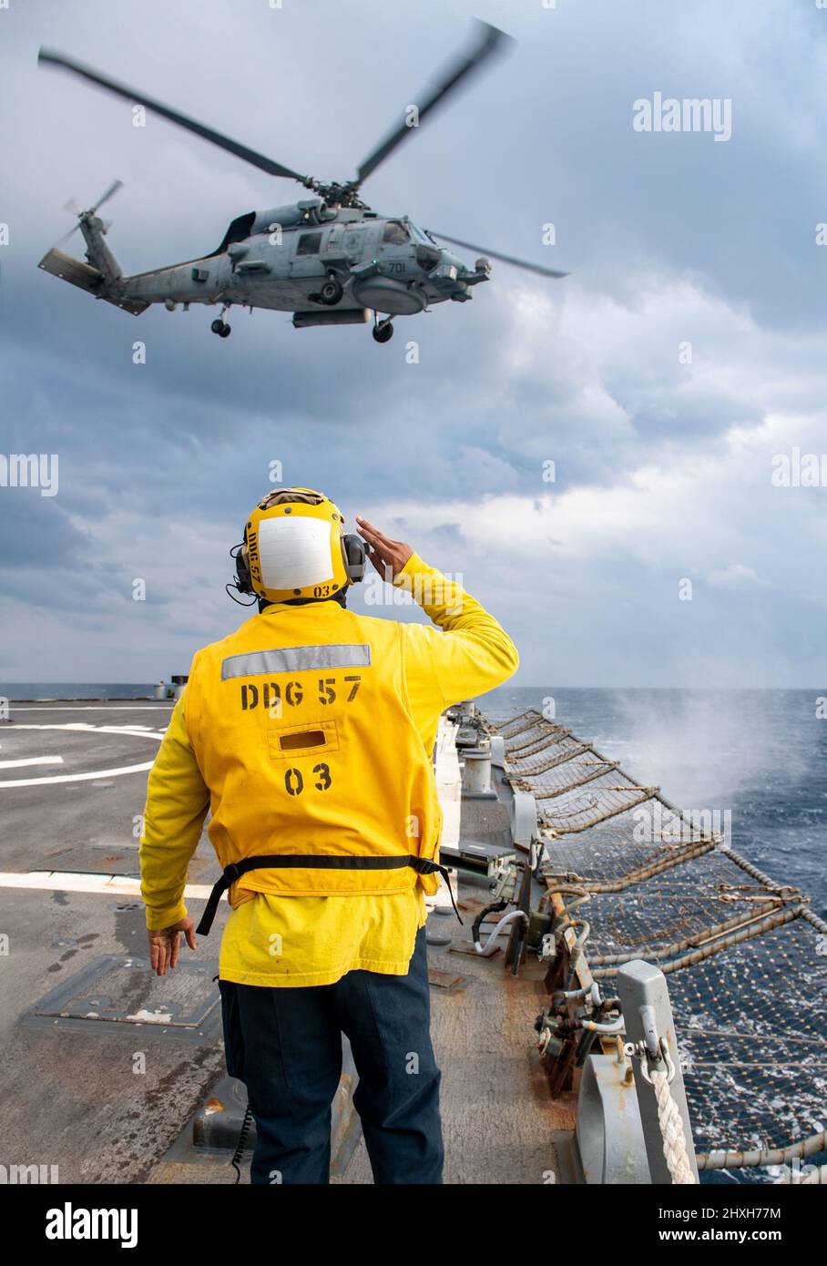 220308-N-HG846-2088 IONISCHES MEER (8. März 2022) – Boatswains Mate 3. Klasse Tra’shaun Cooper aus Homestead, Texas, begrüßt die Piloten eines Hubschraubers MH-60R Sea Hawk, der den „Proud Warriors“ von Helicopter Maritime Strike Squadron (HSM) 72 zugewiesen wurde, als sie das Flugdeck des Lenkraketenzerstörers USS Mitscher der Arleigh Burke-Klasse verlassen (DDG 57), 8. März 2022. Mitscher wird derzeit bei der Harry S. Truman Carrier Strike Group im US-Einsatzgebiet der Sechsten Flotte eingesetzt, um die Interessen der USA, der Alliierten und der Partner in Europa und Afrika zu unterstützen. (USA Navy Foto von Mass Communication Spe Stockfoto