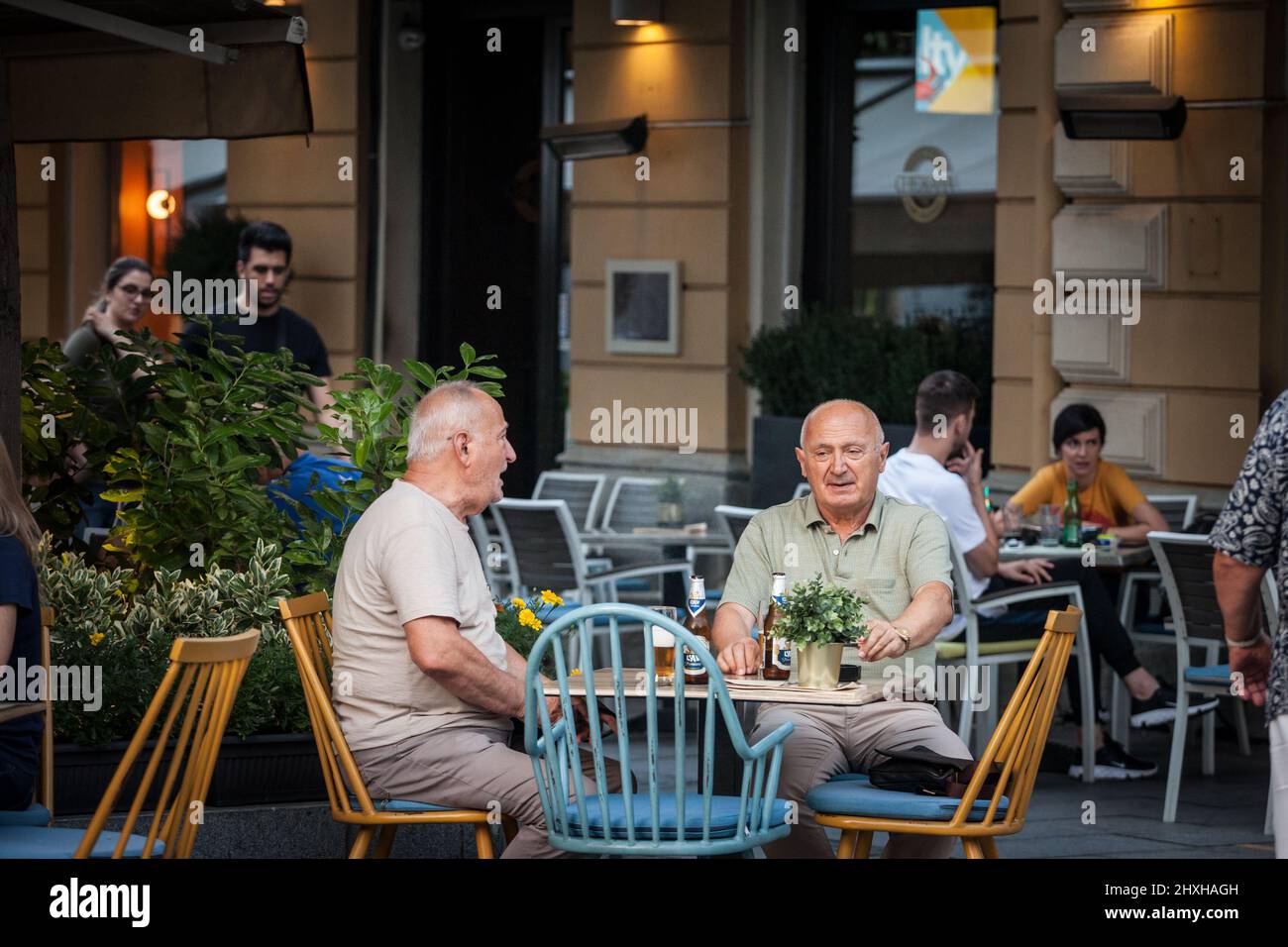 Bild von zwei älteren Männern, die im Sommer am Tisch einer Terrasse einer Bar in Belgrad, Serbien, Bier trinken. Stockfoto