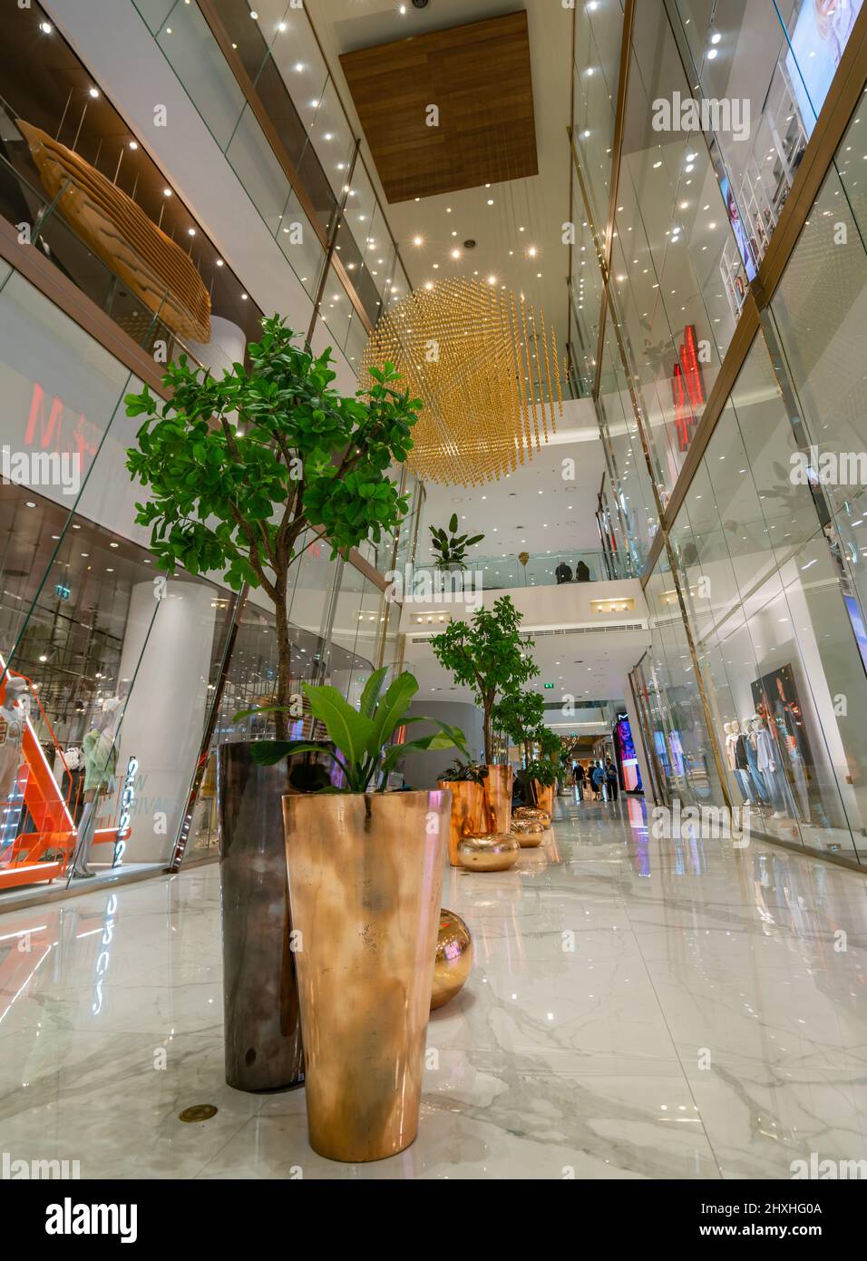 Bangkok, Thailand - 10. März 2022: Wunderschöne Inneneinrichtung mit goldenen Topfpflanzen und Sitz und Kronleuchter auf dem Flur von Icon Siam, Stockfoto