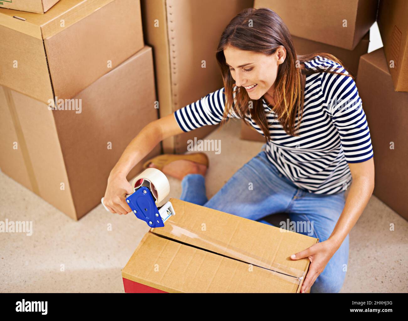 Lasst uns in Bewegung kommen. Aufnahme einer attraktiven jungen Frau, die mit einem Umzug beschäftigt ist. Stockfoto