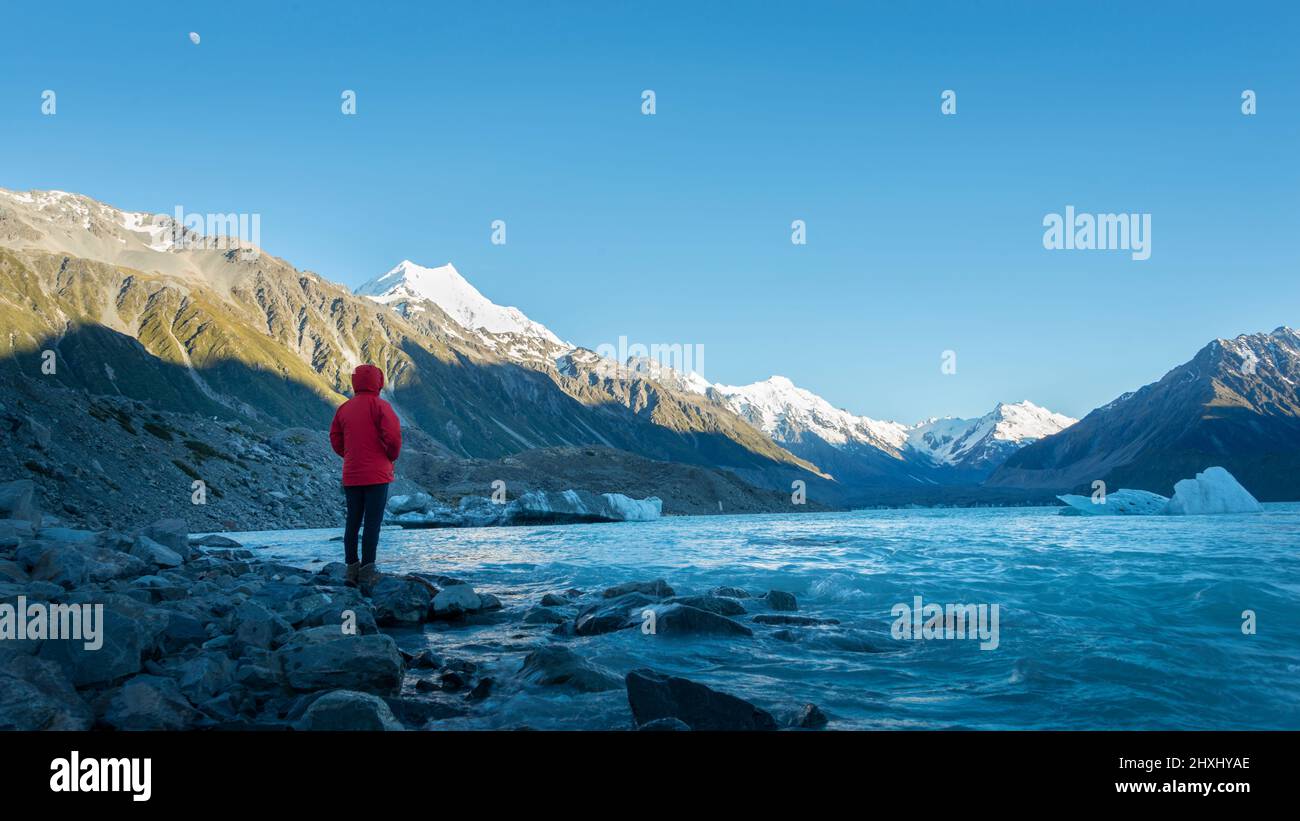 Touristen stehen am Ufer des Tasman Glacier Terminal Lake Blick auf schneebedeckte Berge und Eisberge Stockfoto