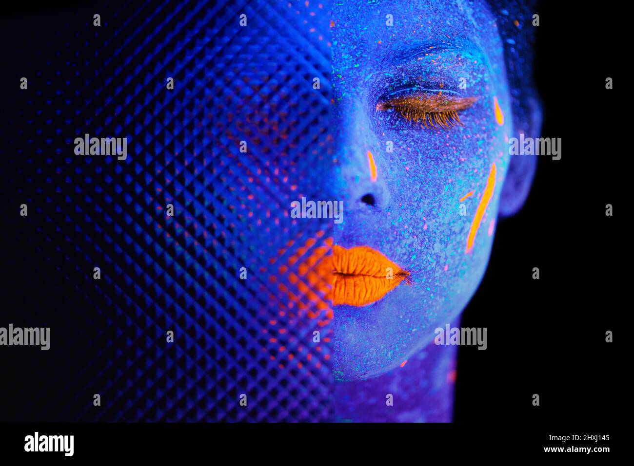 Dies ist Ihre Zeit zu glänzen. Aufnahme einer jungen Frau, die mit Neonfarbe auf ihrem Gesicht posiert. Stockfoto