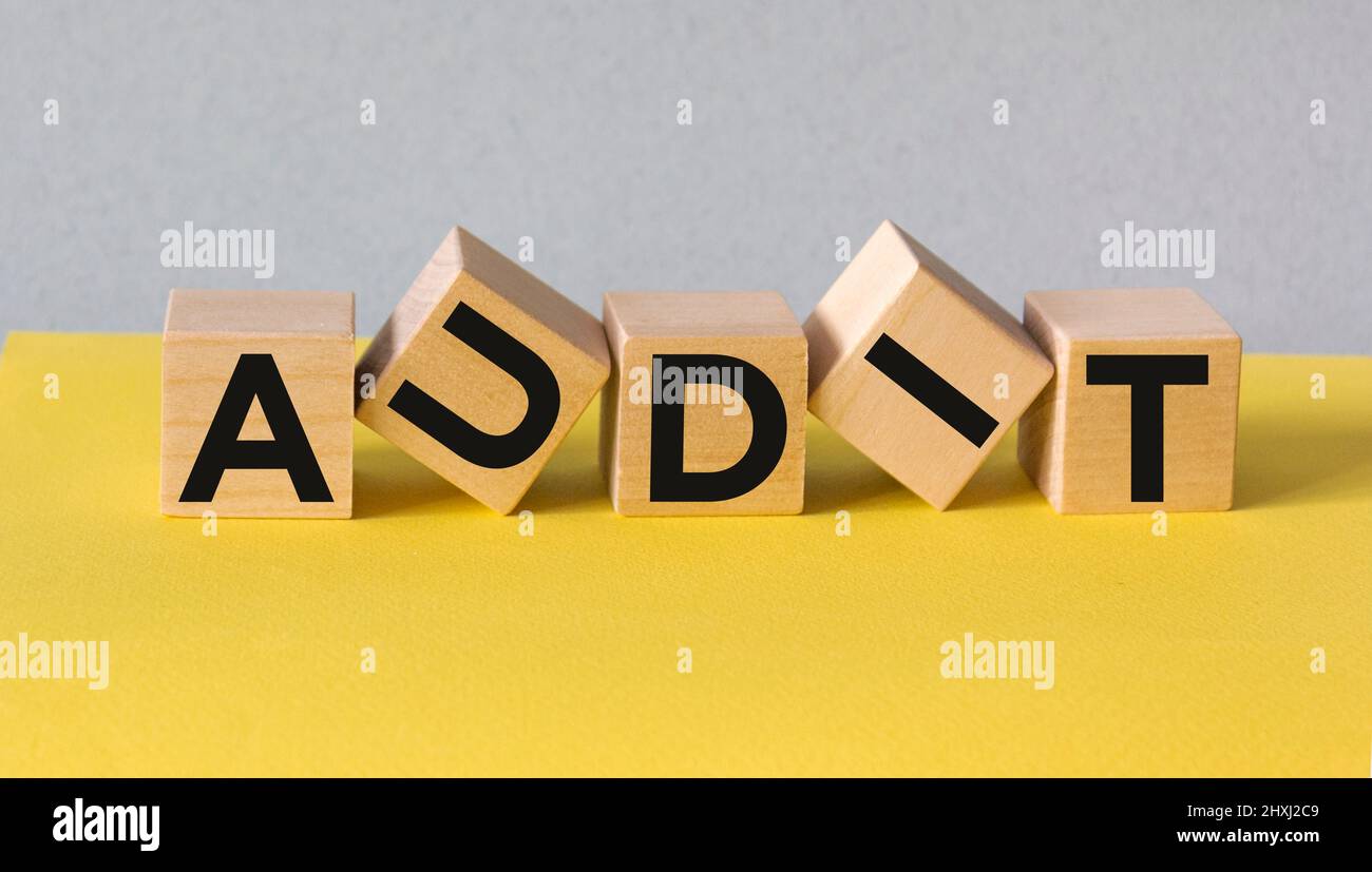 Buchstabenblock in Word Audit auf gelb-blauem Hintergrund. Stockfoto