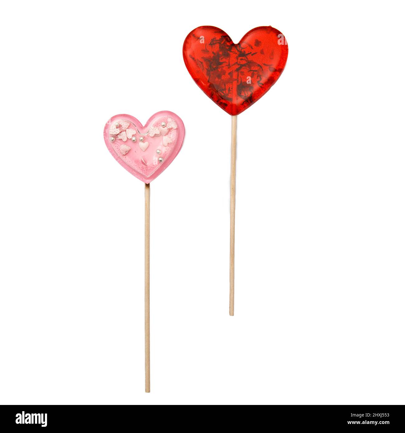 Roter herzförmiger Lollipop mit Kräutern und rosa Stern Lollipop innen auf einem Stock isoliert auf weiß. Geschenk zum Valentinstag. Quadratisches Format Stockfoto