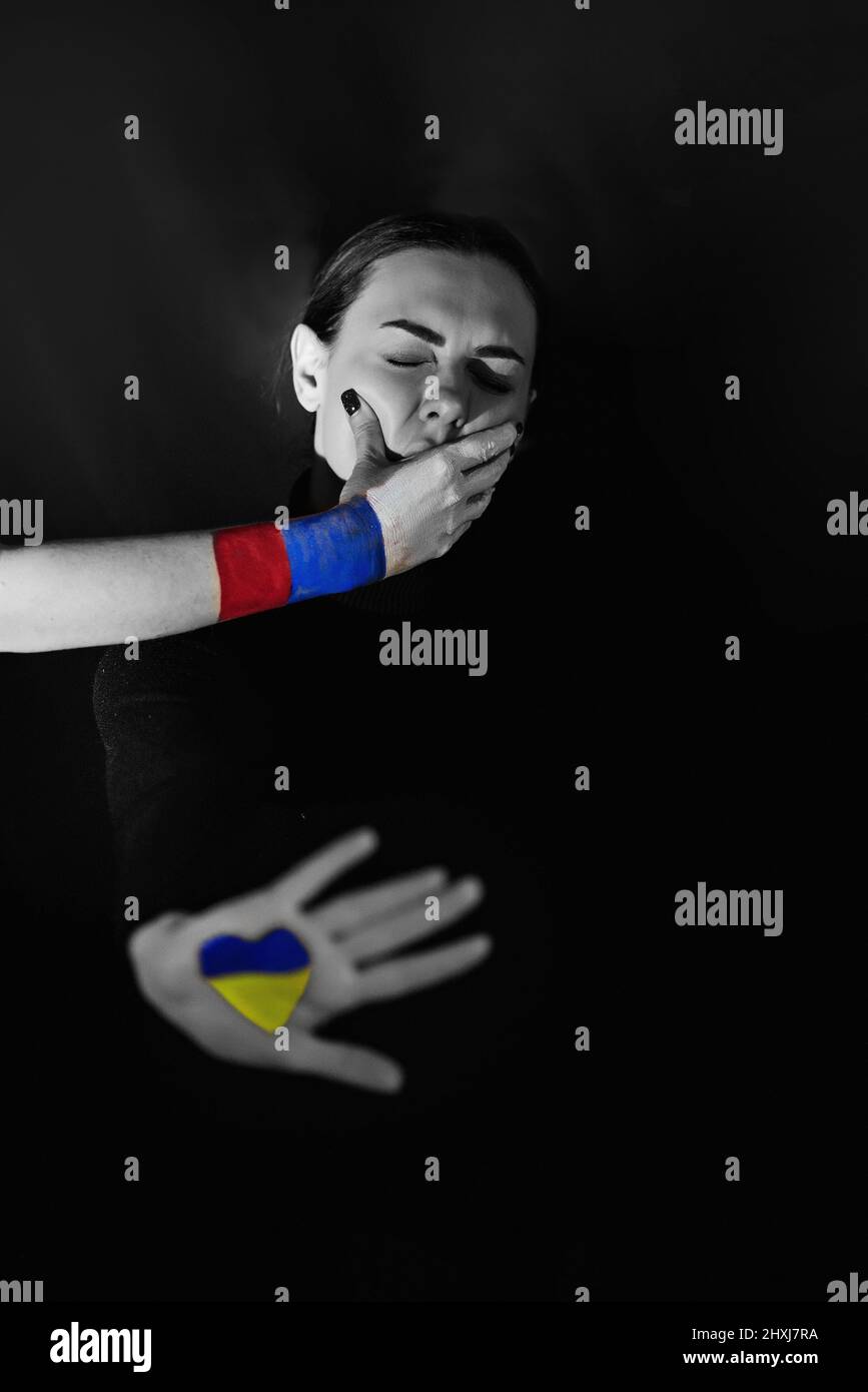 Russland begann den Krieg in der Ukraine am 24.02.2022. Schwarz-weißes Foto einer ukrainischen Frau, die von der Russischen Föderation mit ihrem Mund bedeckt ist. Stockfoto