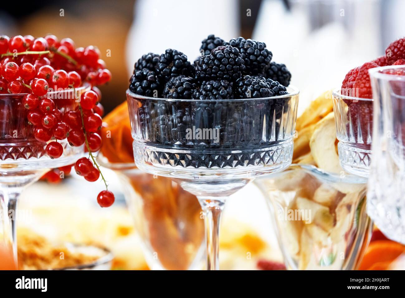 Mehrere Gläser gefüllt mit frischen Beeren der roten Johannisbeere, Brombeere und Himbeere. Beeren des Sommergartens. Stockfoto