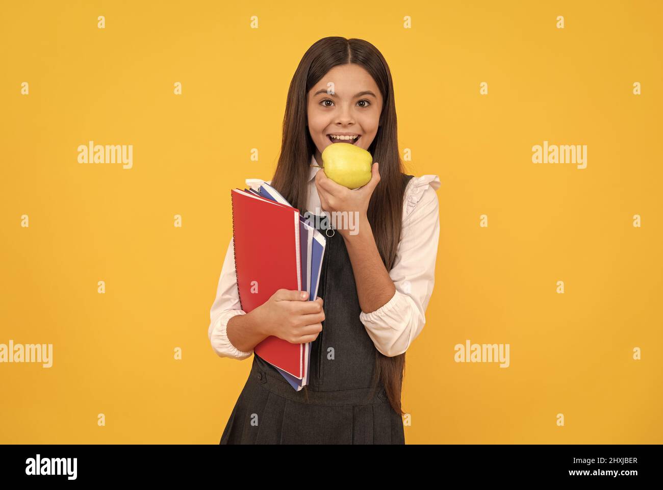 Hunger nach neuem Wissen. Glückliches Schulkind essen Apfel. Lebensmittelbildung. Ernährungsbildung Stockfoto